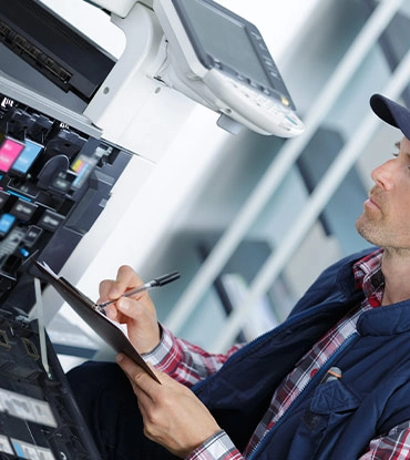 Technicien consultant une tablette devant une machine