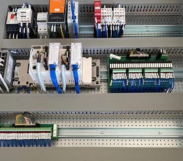 Intérieur d’armoire électrique câblée : automate, relais et borniers